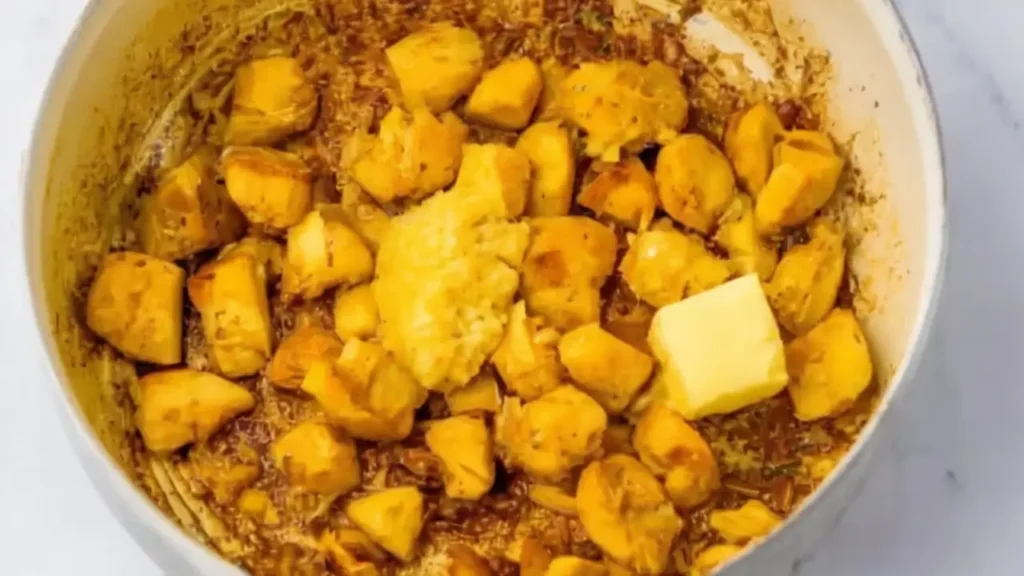 adding garlic butter to Parmesan Chicken and Potatoes