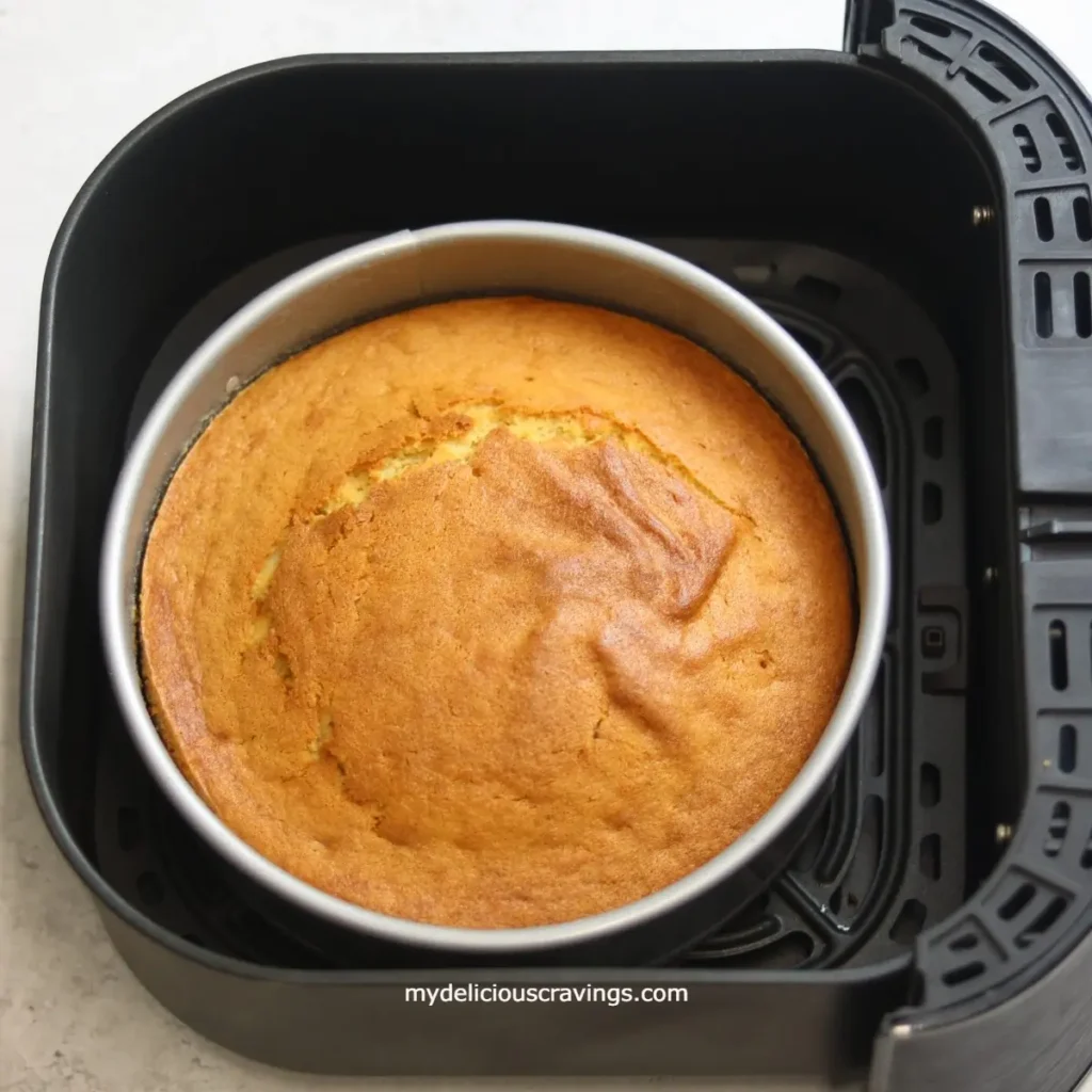 Air Fryer Cake – A freshly baked vanilla cake inside an air fryer, golden brown and moist.